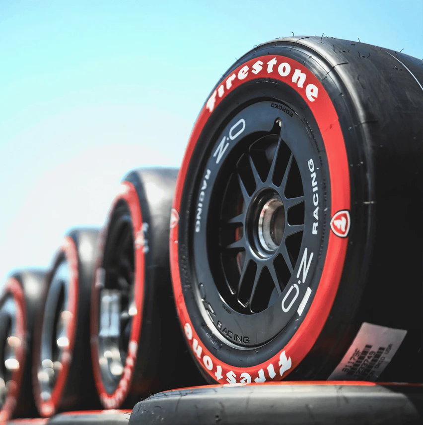Firestone racing tires with red sidewalls and alloy wheels