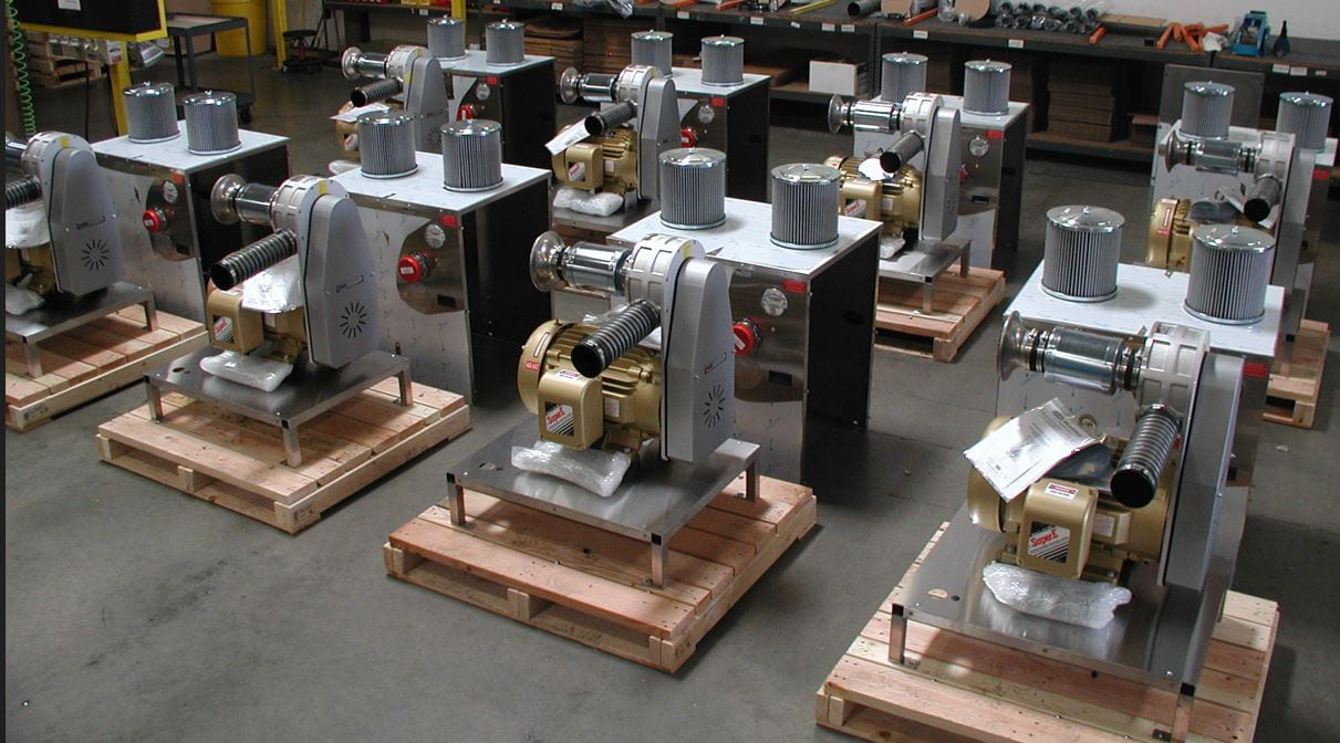 Sonic centrifugal air blowers with enclosures lined up on a production floor