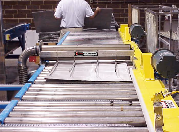 Sonic Air Systems industrial air knife system on a conveyor belt.